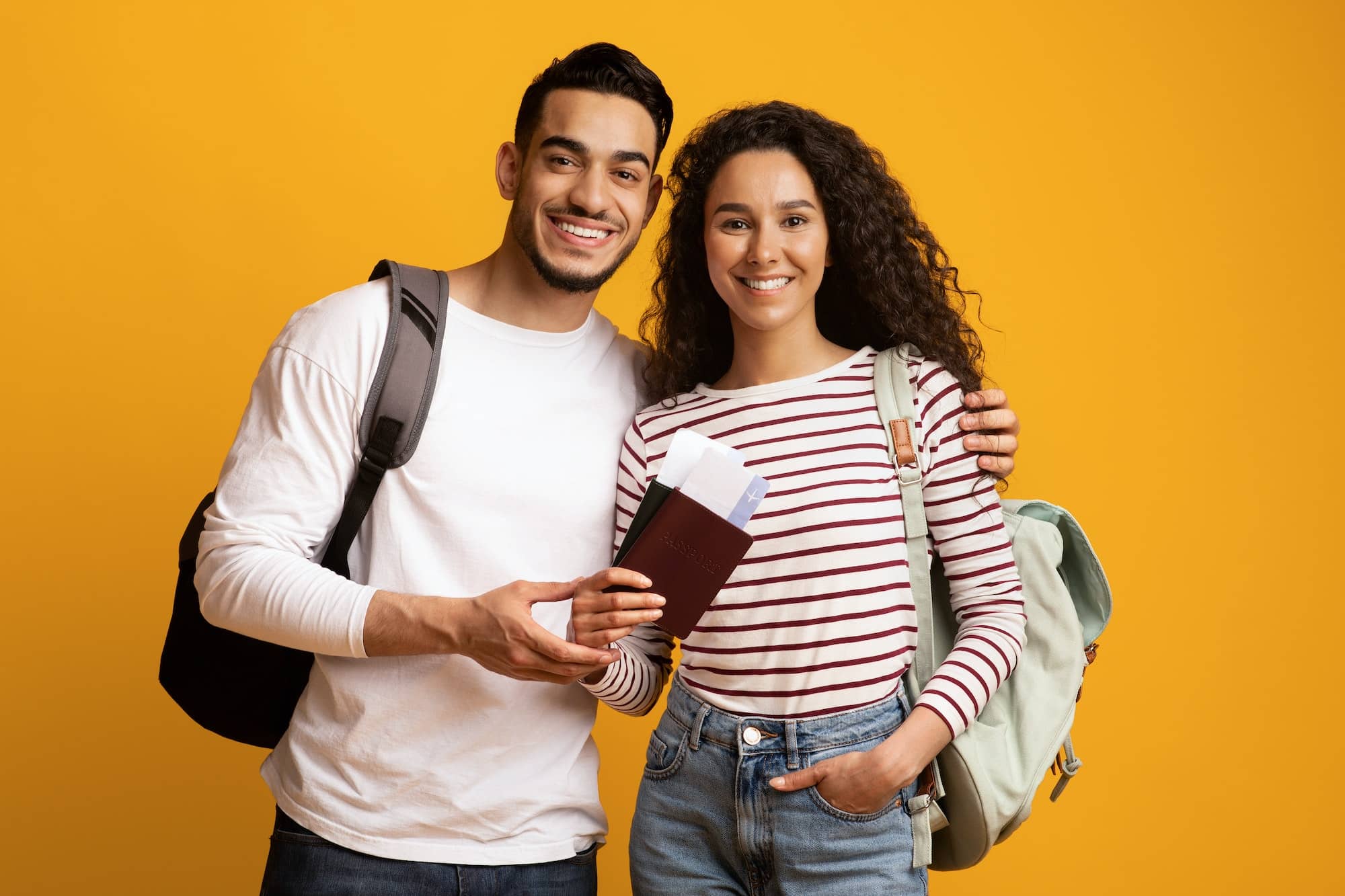 Happy Travellers. Smiling Arab Couple With Backpacks, Passports And Travel Tickets