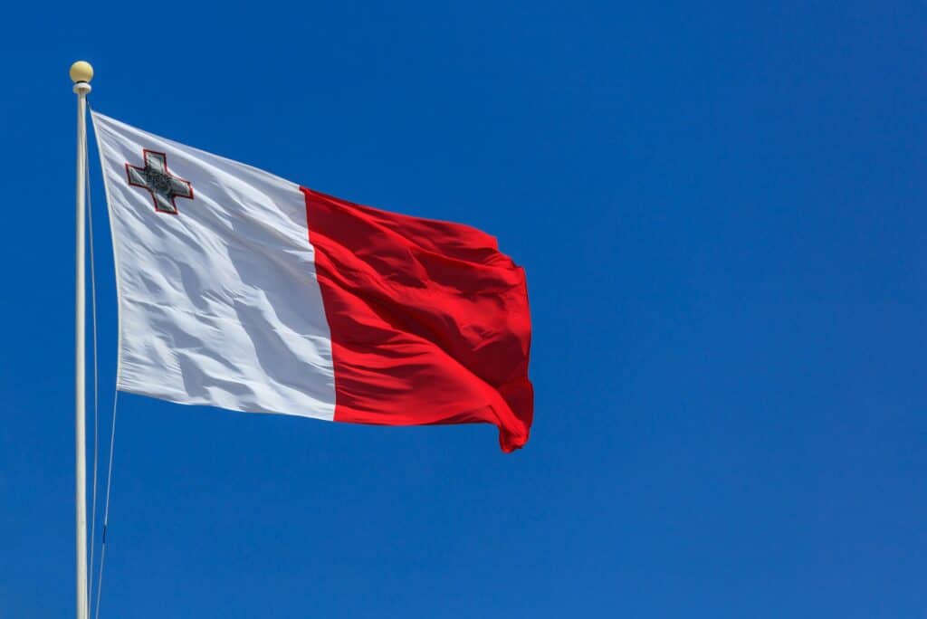 Malta Flag. Malta Flag On A Pole Waving On Blue Sky Background