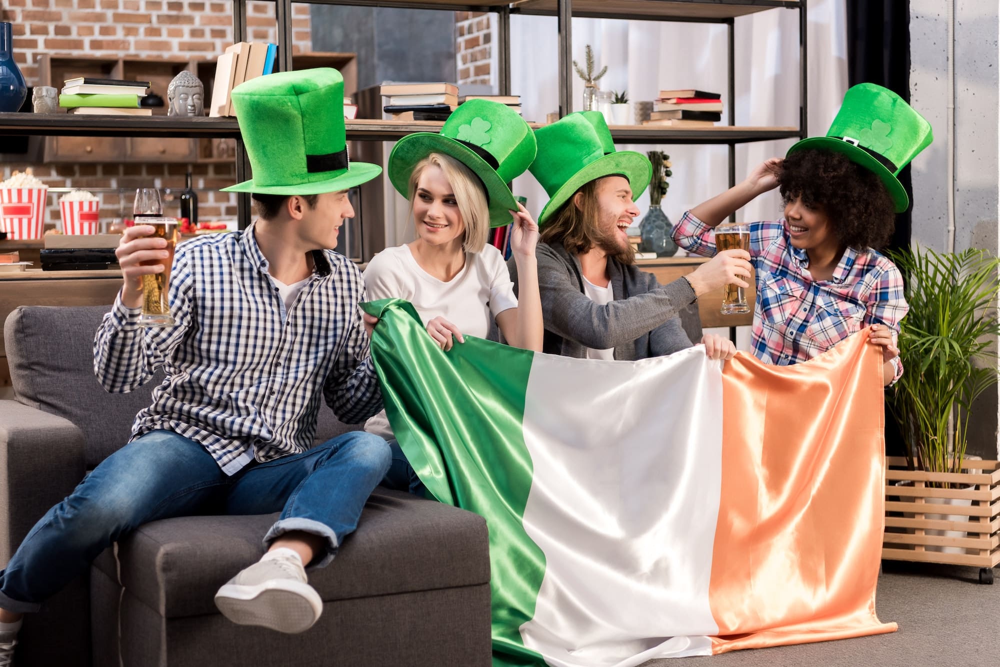 Multiethnic Friends Celebrating Saint Patrick Day At Home And Holding Irish Flag