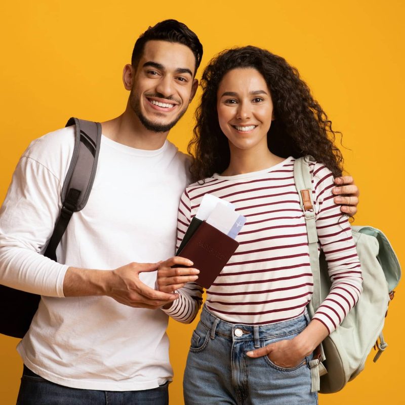 Happy Travellers. Smiling Arab Couple With Backpacks, Passports And Travel Tickets