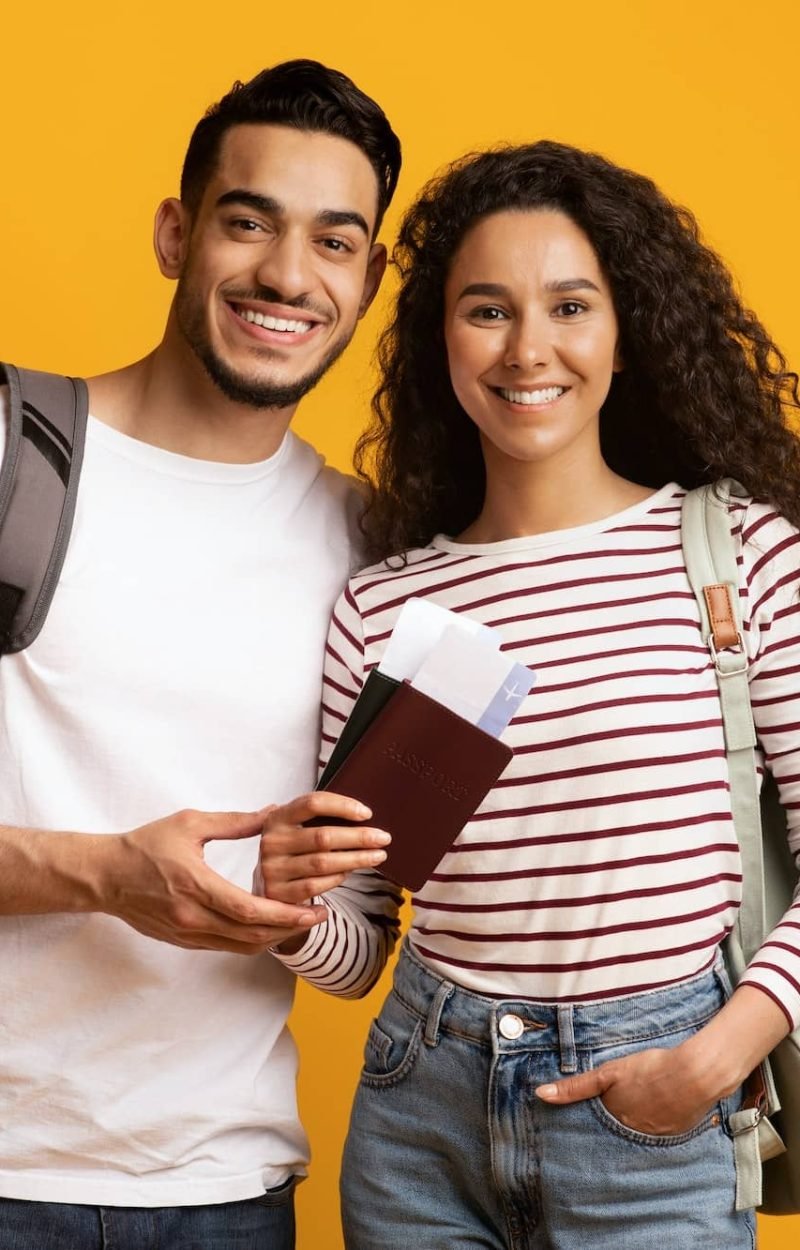 Happy Travellers. Smiling Arab Couple With Backpacks, Passports And Travel Tickets