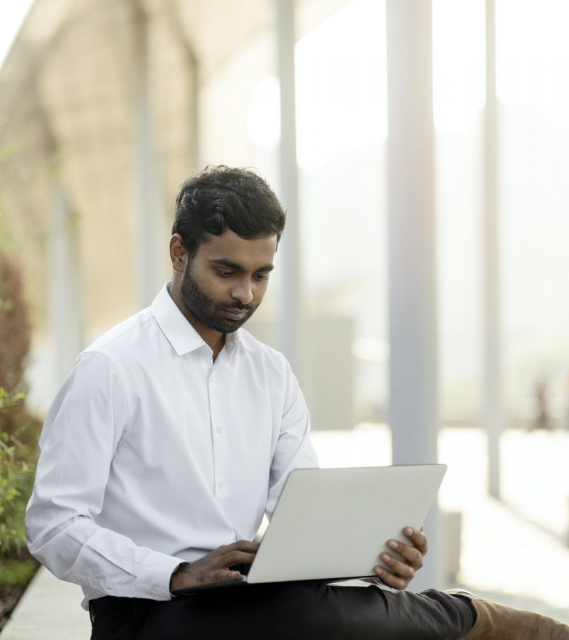 Indian freelancer copywriter using laptop computer typing working online sitting at workplace