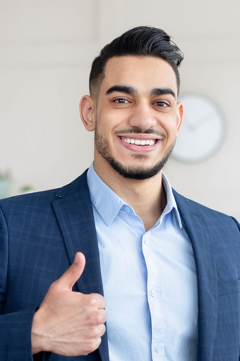 smiling-arab-businessman-holding-computer-showing-PAUEEHC.jpg
