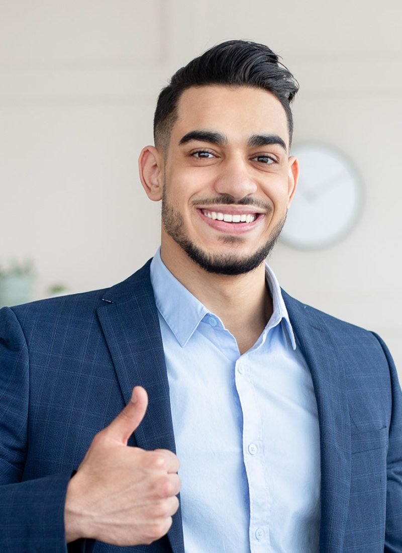 Smiling-Arab-Businessman-Holding-Computer-Showing-Paueehc.jpg